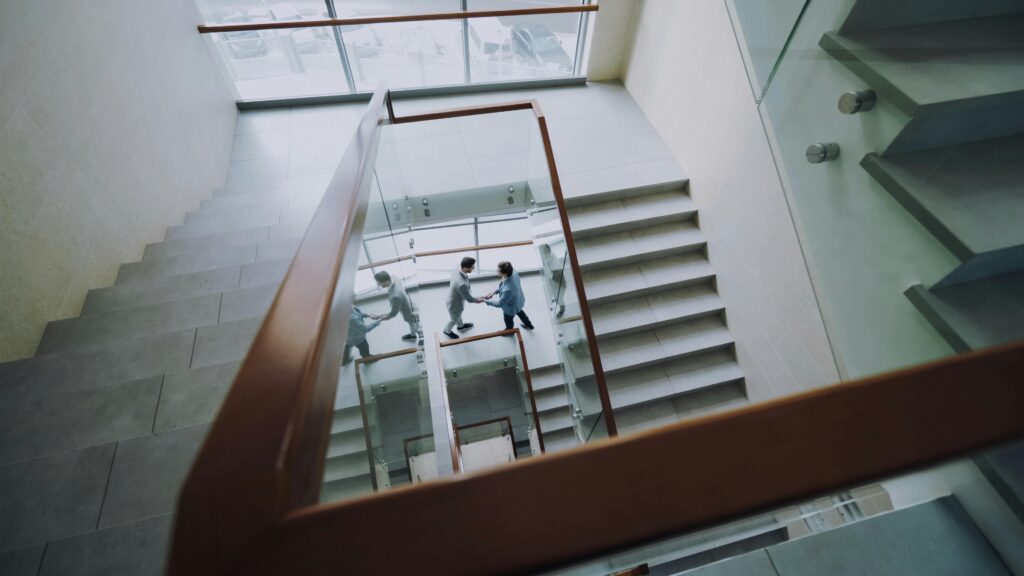 Aerial view of business professionals shaking hands on a modern staircase.